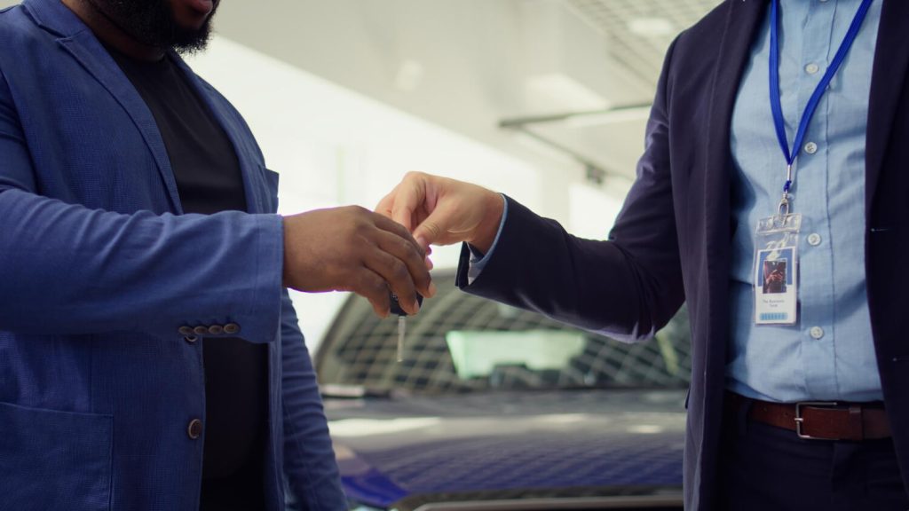 Vendedor entrega chaves na mão de cliente, simbolizando a quitação do consignado CLT e a liberdade financeira com suporte da Facta Online.